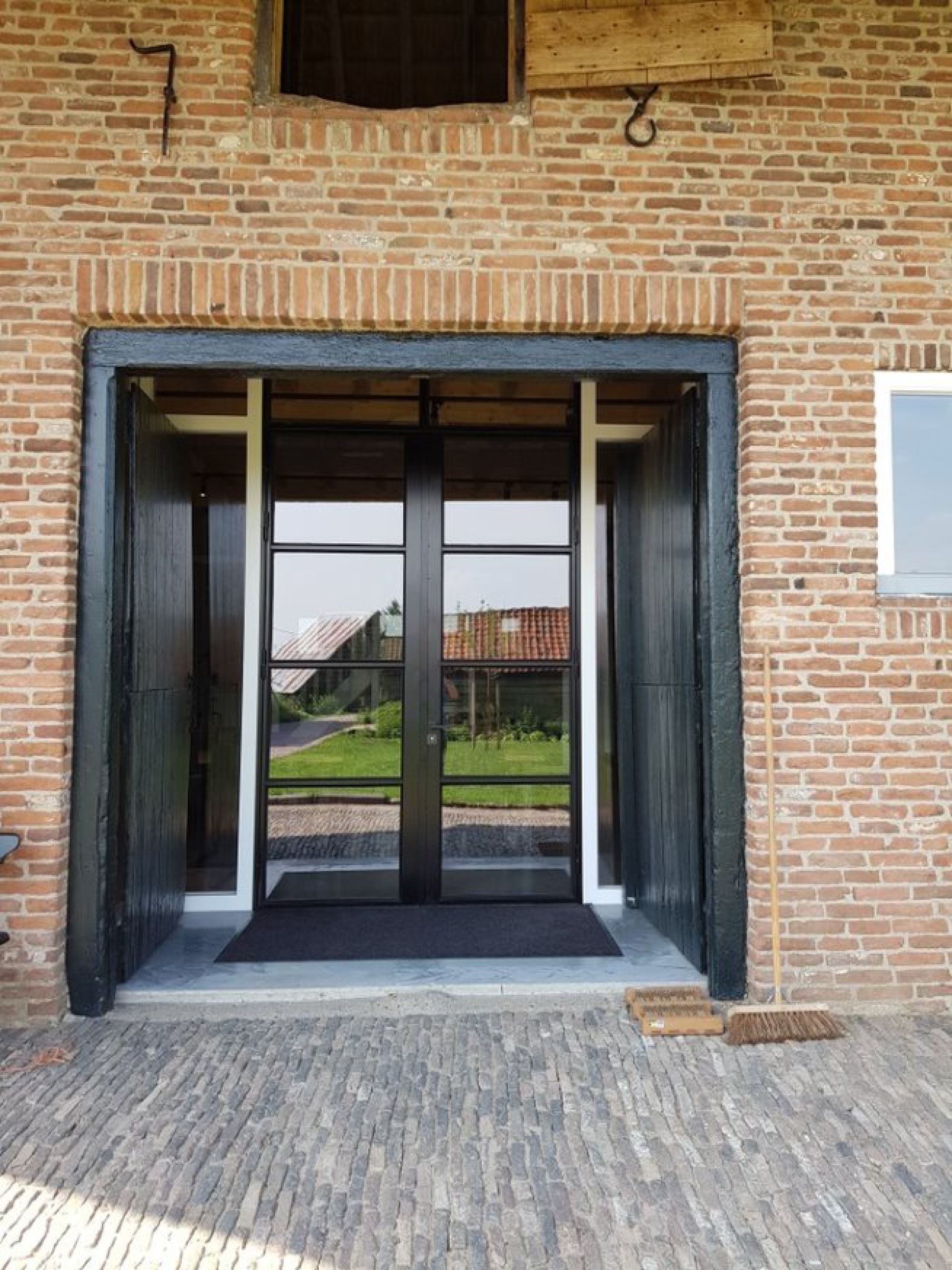 Grote dubbele deuren in een landhuis met geisoleerd glas HR+++ voorzien van zinkcoating antiroest. 